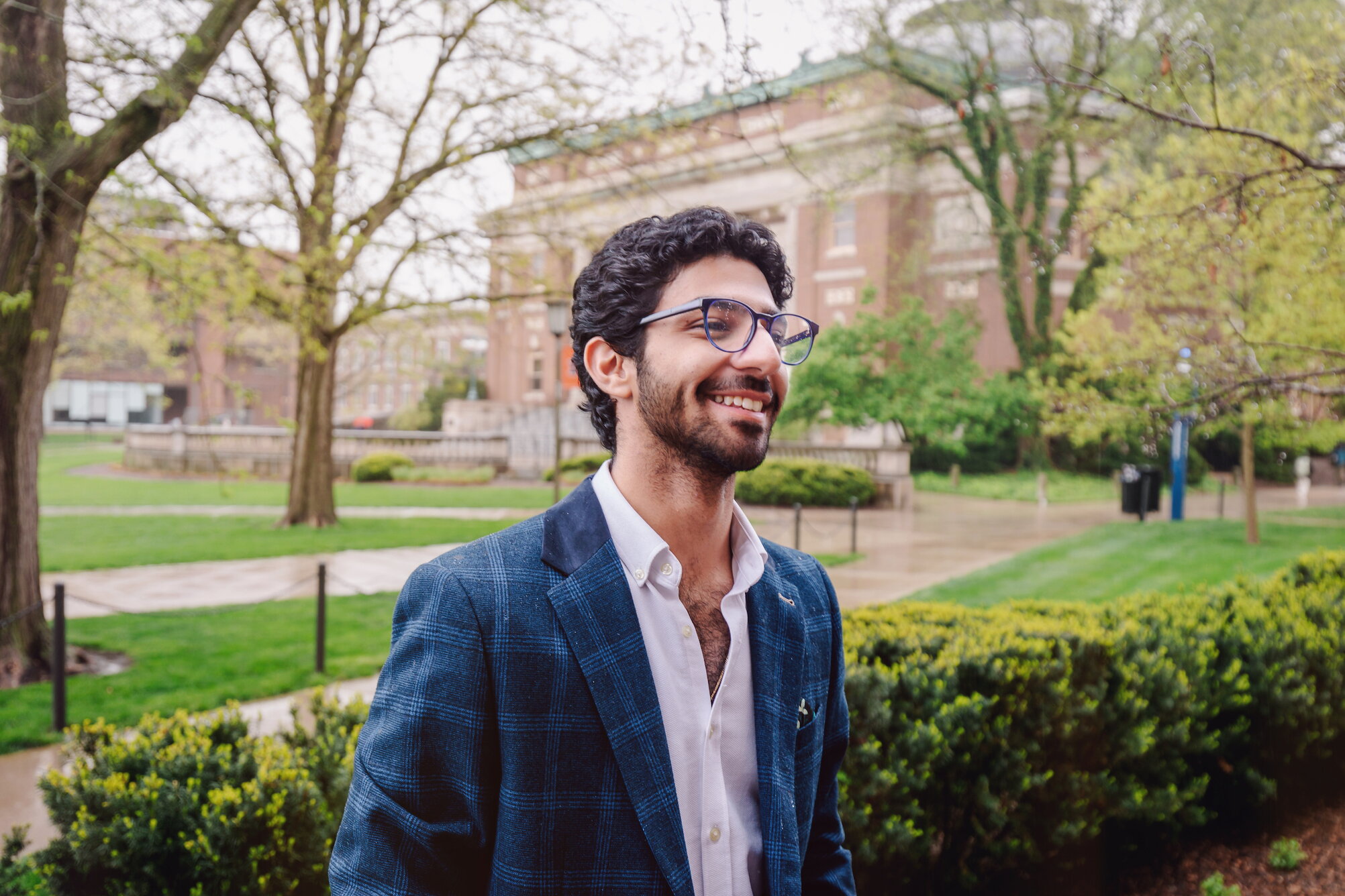 Student on the Quad dressed in business casual attire on a rainy day.